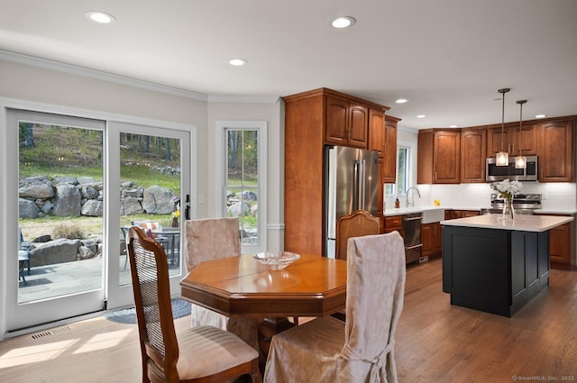 kitchen featuring decorative light fixtures, appliances with stainless steel finishes, light countertops, light wood-style floors, and recessed lighting