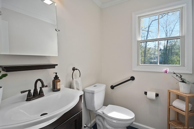 bathroom with baseboards, ornamental molding, toilet, and vanity