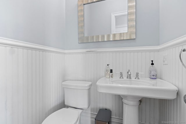 bathroom with wainscoting and toilet