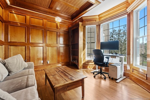 home office with ornamental molding, light wood finished floors, wood ceiling, wood walls, and beam ceiling