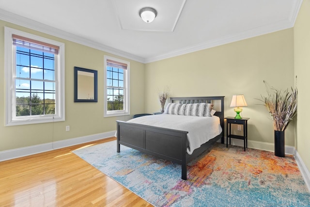 bedroom featuring crown molding, baseboards, and wood finished floors