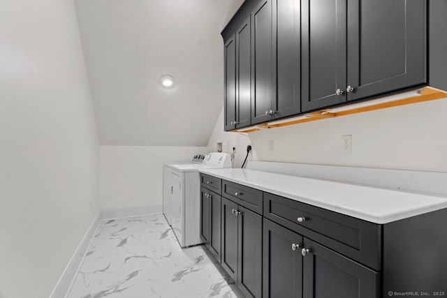 clothes washing area featuring cabinet space, washer and clothes dryer, marble finish floor, and baseboards