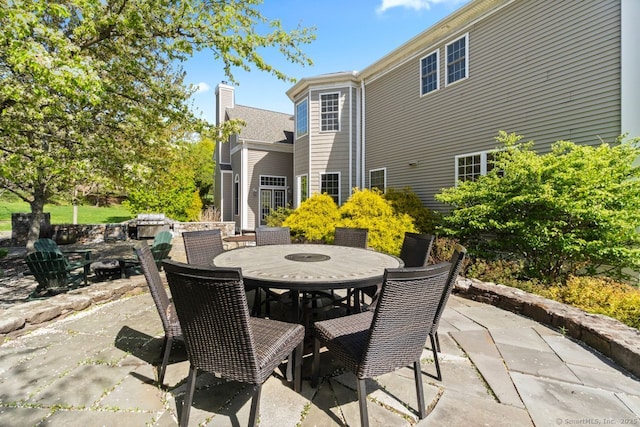 view of patio with an outdoor fire pit and outdoor dining area