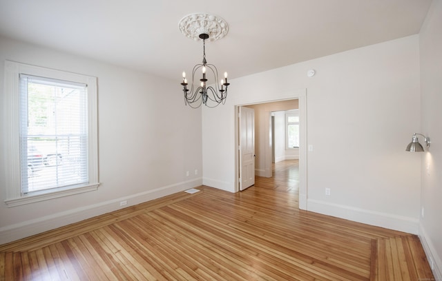 221 Broadway, Norwich, CT 06360 - spare room with baseboards, visible vents, light wood finished floors, and a chandelier