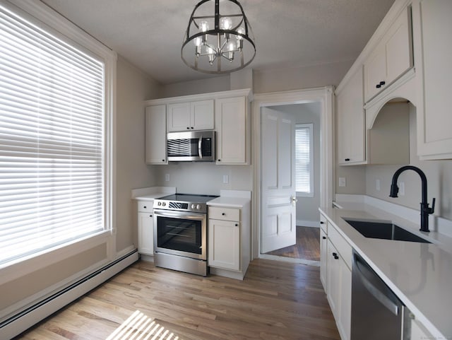 221 Broadway, Norwich, CT 06360 - kitchen featuring baseboard heating, a sink, light countertops, a chandelier, and stainless steel appliances