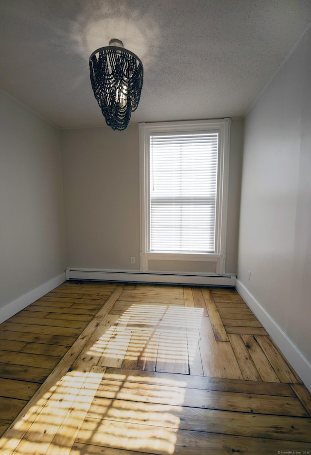 221 Broadway, Norwich, CT 06360 - spare room featuring baseboards, a textured ceiling, a baseboard heating unit, and hardwood / wood-style flooring
