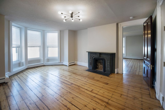 221 Broadway, Norwich, CT 06360 - unfurnished living room featuring a textured ceiling, baseboards, wood-type flooring, a baseboard heating unit, and an inviting chandelier