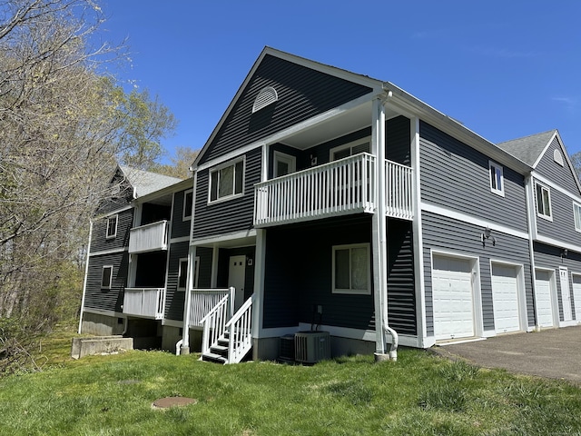 103D Wendover Dr Unit D, Monroe, CT 06468 - view of side of home featuring driveway, a yard, an attached garage, and a balcony