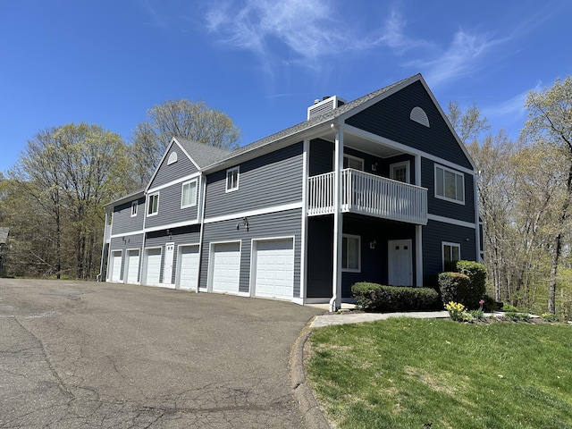 103D Wendover Dr Unit D, Monroe, CT 06468 - view of front of property featuring a balcony, driveway, a chimney, a front yard, and an attached garage