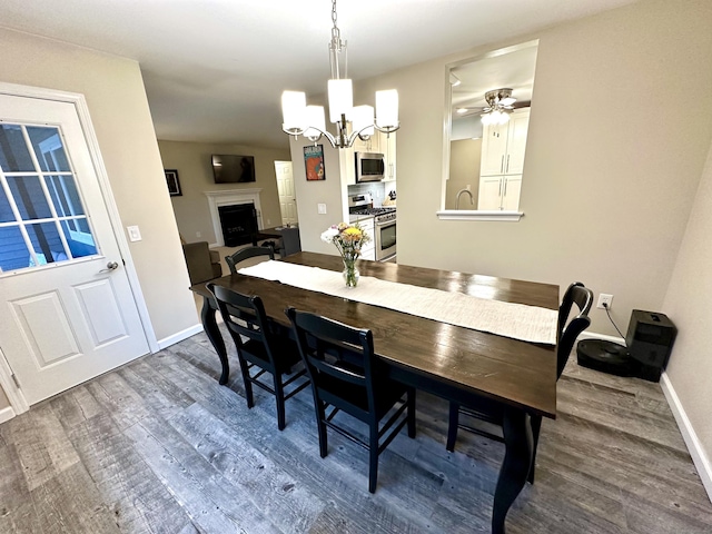 103D Wendover Dr Unit D, Monroe, CT 06468 - dining area with dark wood-style flooring, baseboards, a chandelier, and a fireplace with raised hearth