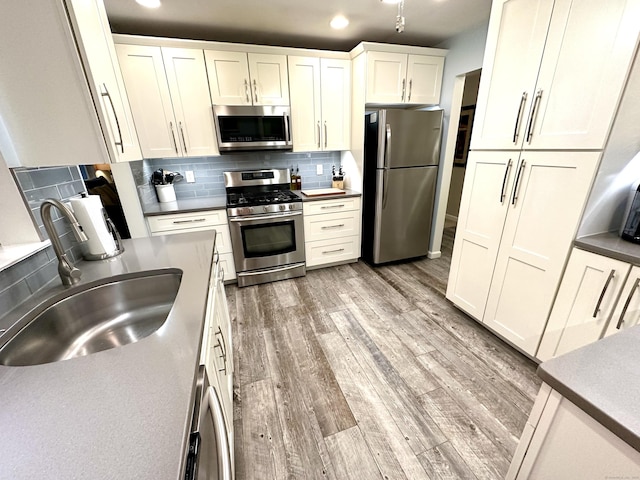 103D Wendover Dr Unit D, Monroe, CT 06468 - kitchen with appliances with stainless steel finishes, a sink, tasteful backsplash, light wood finished floors, and recessed lighting