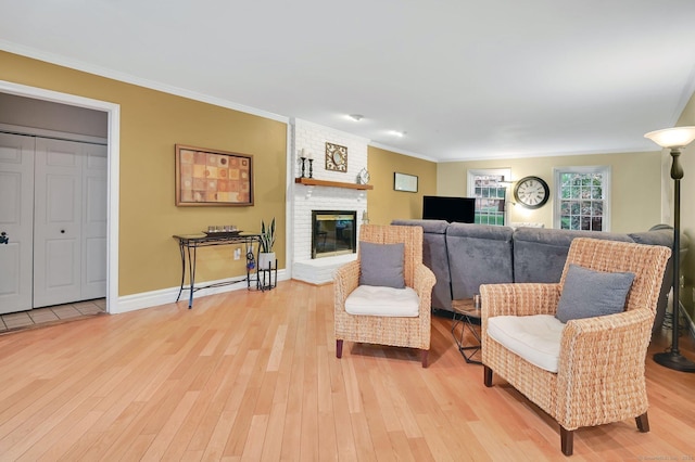 living area with light wood finished floors, ornamental molding, baseboards, and a brick fireplace