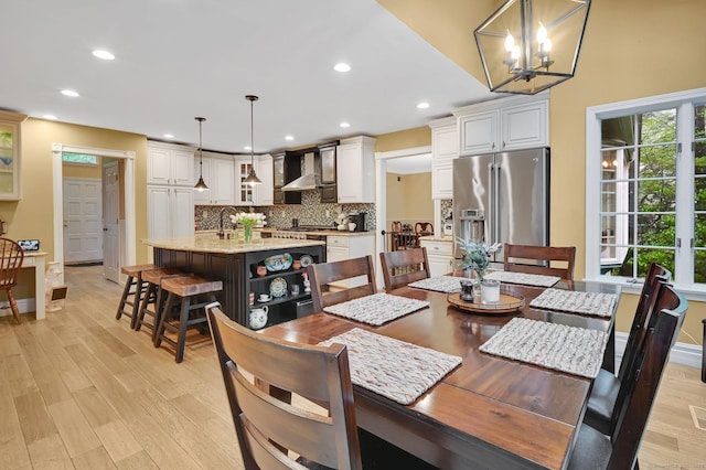 dining room featuring light wood-style flooring, recessed lighting, baseboards, and a chandelier