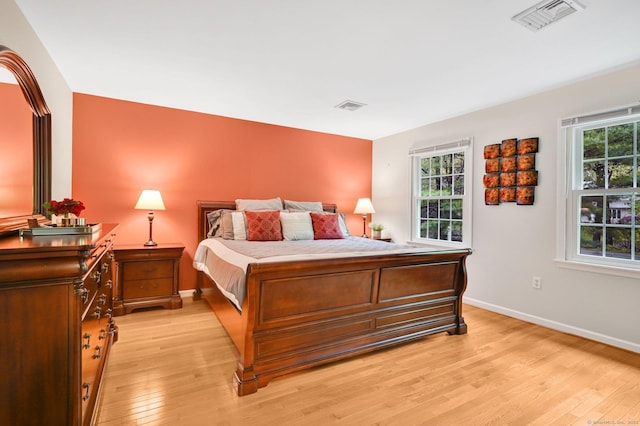 bedroom with light wood finished floors and baseboards