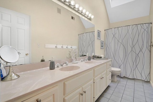 full bathroom with tile patterned flooring, double vanity, toilet, and a skylight