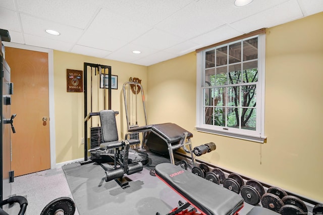 exercise room with a paneled ceiling, baseboards, and recessed lighting
