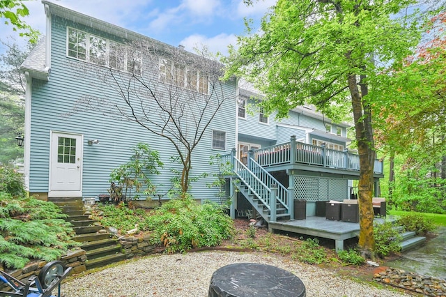 back of house featuring stairs and a wooden deck