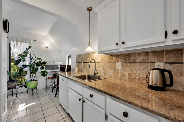 kitchen featuring plenty of natural light, a sink, light tile patterned flooring, and white dishwasher