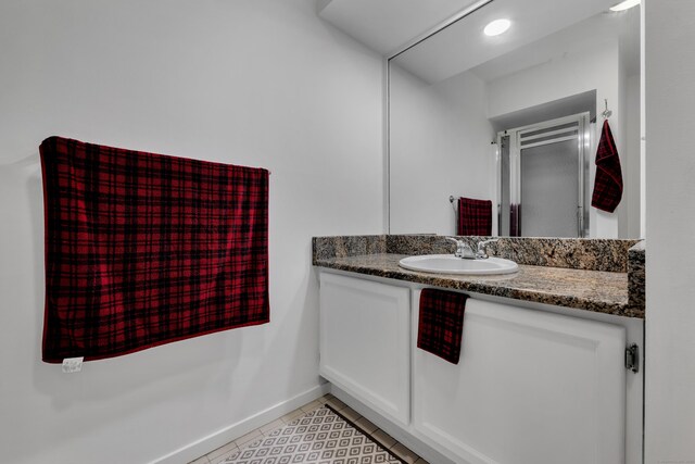 bathroom featuring vanity, tile patterned flooring, and baseboards