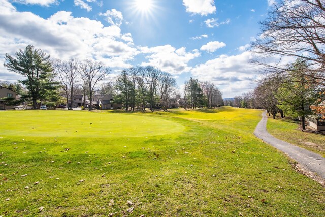 view of property's community with golf course view and a yard