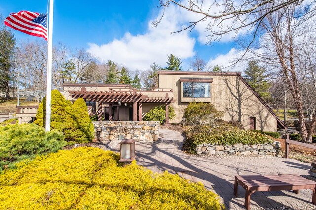 mediterranean / spanish-style house with stucco siding and a pergola