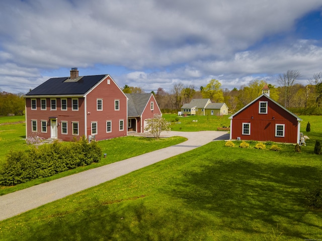 exterior space featuring concrete driveway, a barn, and an outdoor structure