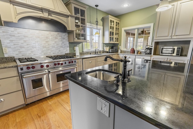 kitchen featuring a sink, hanging light fixtures, custom exhaust hood, and stainless steel appliances