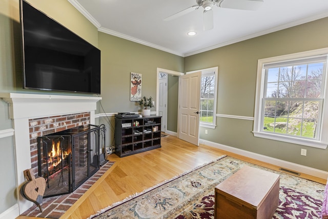 living room featuring visible vents, ornamental molding, ceiling fan, and wood finished floors