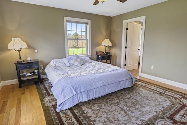 bedroom with baseboards, a ceiling fan, and wood finished floors