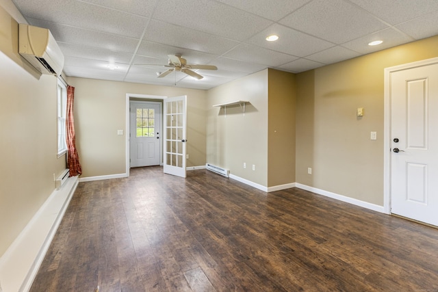entrance foyer featuring a ceiling fan, a drop ceiling, a wall mounted AC, and dark wood-style floors