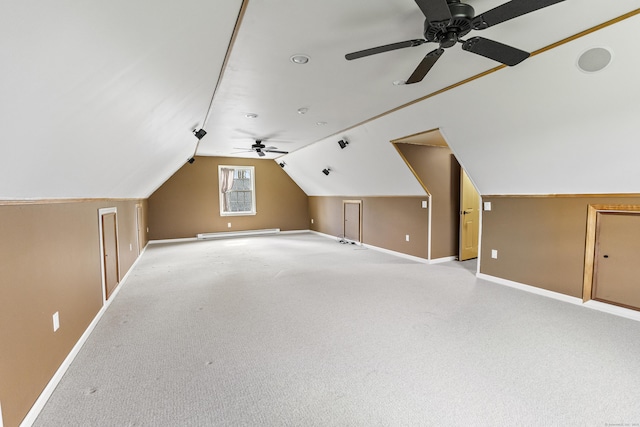additional living space with ceiling fan, vaulted ceiling, light carpet, and baseboards
