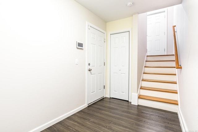 interior space with baseboards, dark wood-style floors, and stairs