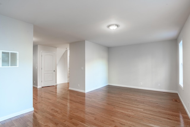 spare room featuring visible vents, light wood-style flooring, baseboards, and a wealth of natural light