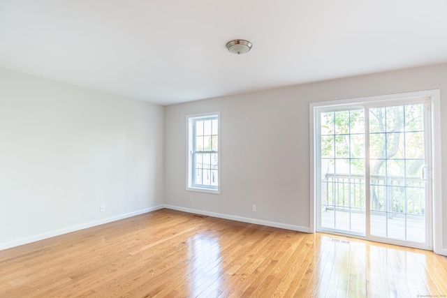 empty room with baseboards and light wood-type flooring