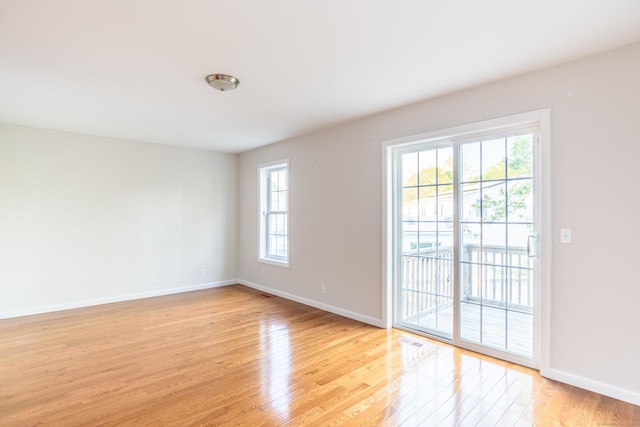 unfurnished room featuring baseboards, light wood finished floors, and visible vents