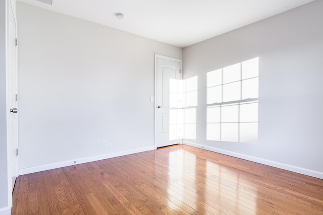 empty room with baseboards and wood finished floors