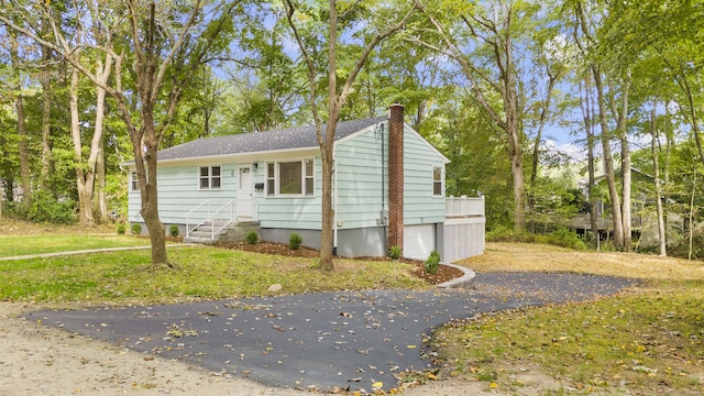 exterior space with driveway and a chimney