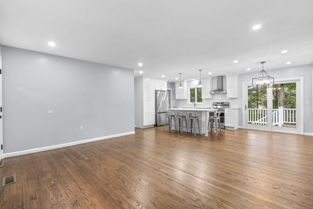 living area with recessed lighting, wood finished floors, and visible vents