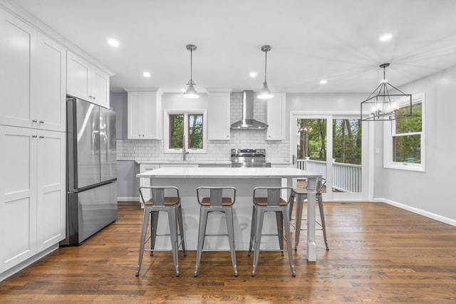 kitchen featuring appliances with stainless steel finishes, decorative backsplash, wall chimney exhaust hood, and a wealth of natural light