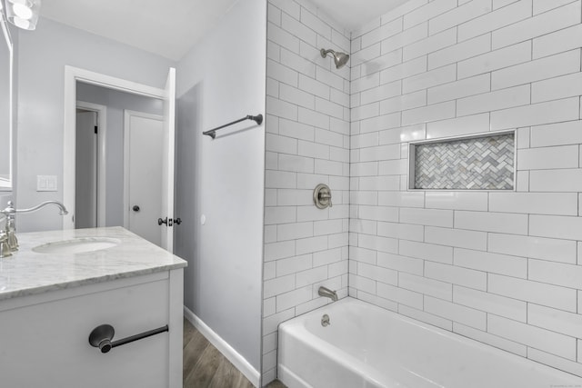 full bath featuring shower / bath combination, baseboards, wood finished floors, and vanity