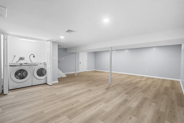 washroom featuring laundry area, baseboards, wood finished floors, visible vents, and washer and clothes dryer