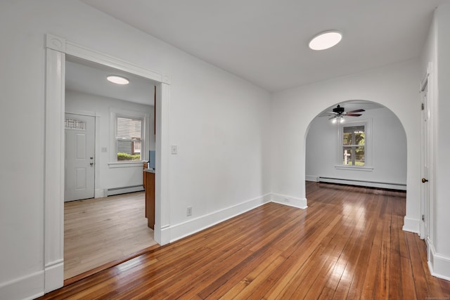 291 E St, New Britain, CT 06051 - spare room featuring a ceiling fan, plenty of natural light, a baseboard radiator, and arched walkways