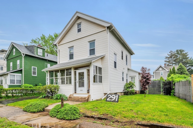 291 E St, New Britain, CT 06051 - view of front of property with a sunroom, fence, and a front lawn
