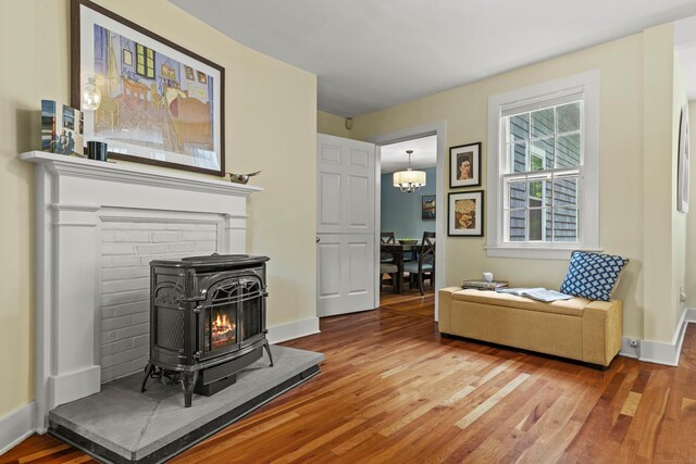 34 W Ave, Essex, CT 06426 - living area featuring wood finished floors, a wood stove, and a chandelier