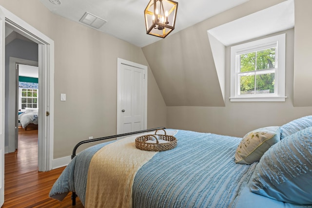 34 W Ave, Essex, CT 06426 - bedroom with wood finished floors, multiple windows, a closet, lofted ceiling, and a chandelier