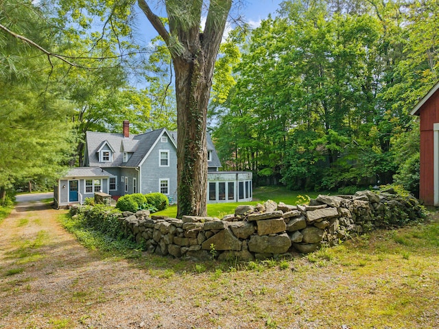 34 W Ave, Essex, CT 06426 - view of front facade featuring a chimney, an outbuilding, a front yard, and a sunroom