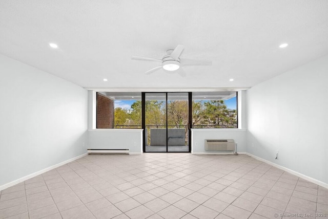 empty room featuring a wall mounted air conditioner, a wealth of natural light, a wall of windows, and a baseboard heating unit