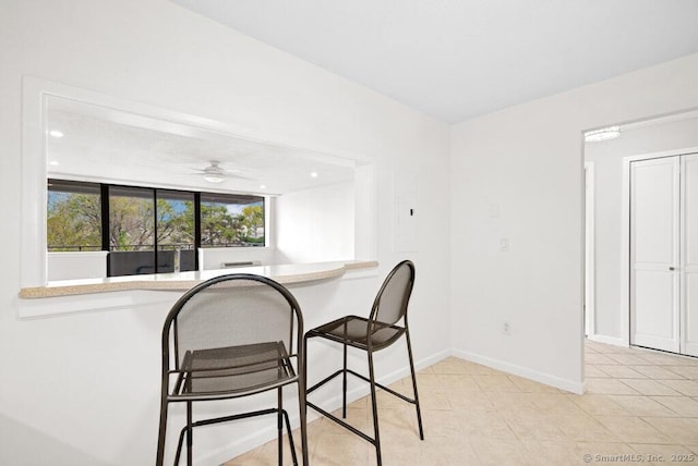 tiled dining area featuring baseboards and ceiling fan