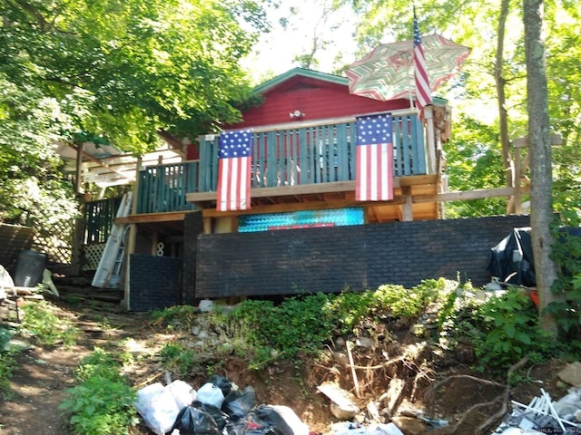 rear view of property with stairs and a wooden deck