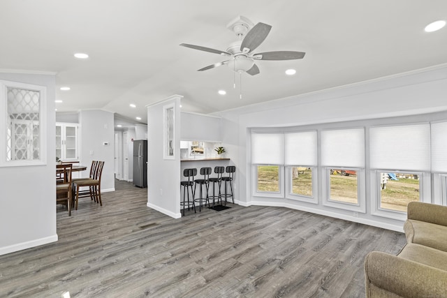 living room with crown molding, recessed lighting, baseboards, a ceiling fan, and wood finished floors